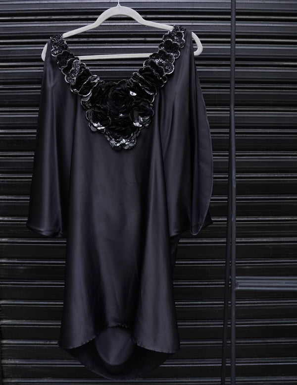 Vestido negro de raso con flores bordadas del entejuelas en escote e Ginebra