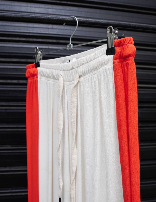 Pantalón de crepe off white con detalle de tira roja en laterales de Maria Cher